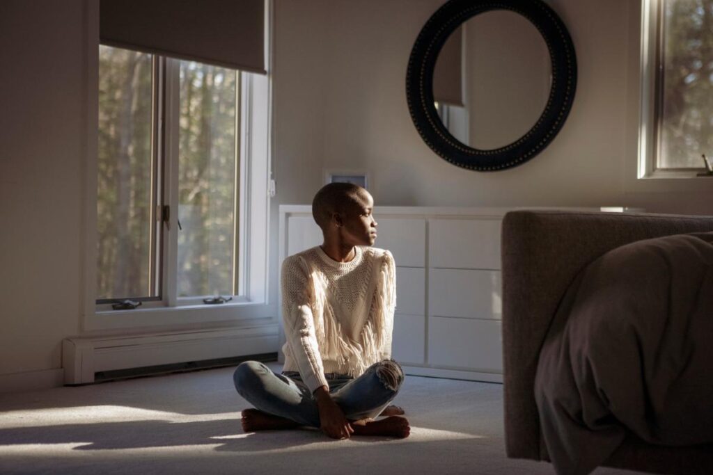 person sitting on floor in home wondering is heroin a depressant